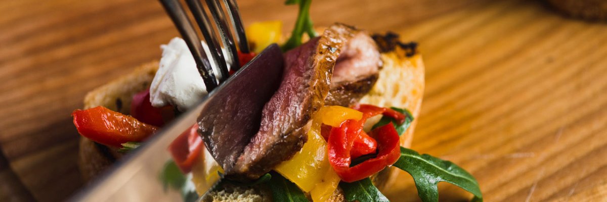 Bild zeigt Ausschnitt beim Essen einer Tartine mit Messer und Gabel